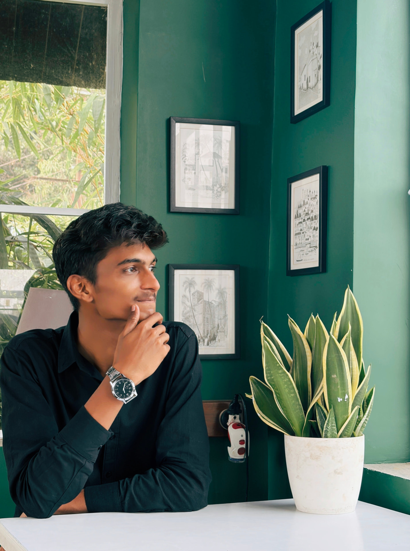 Aditya Bawane seated beside a plant